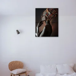 Afrikaanse vrouw met gekleurde hoofddoek als sfeerimpressie aan de muur