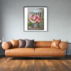 Roze, gele bloemen in vaas op stoel als sfeerimpressie aan de muur