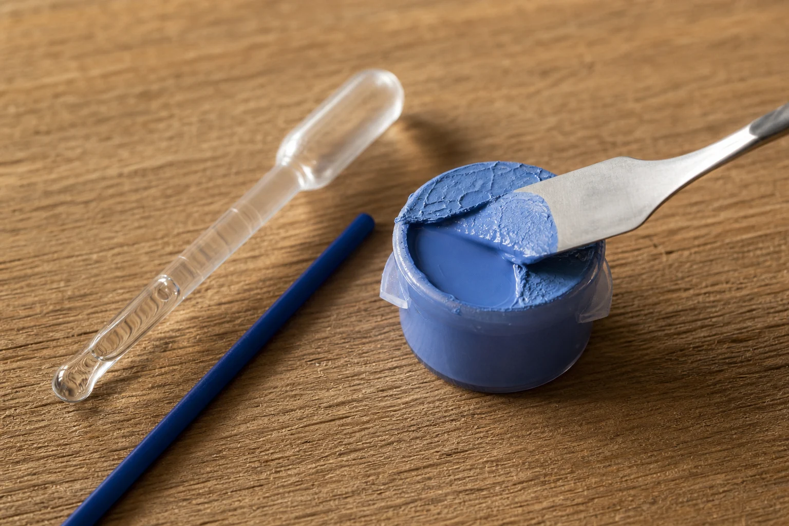 Dun droog vel dat van een potje zachte blauwe acrylverf wordt gelicht