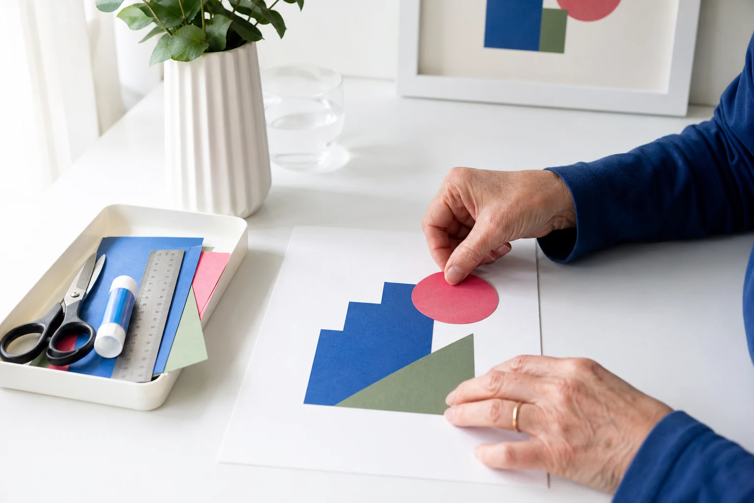 Volwassen handen die een geometrische collage maken met papier schaar lijm en liniaal