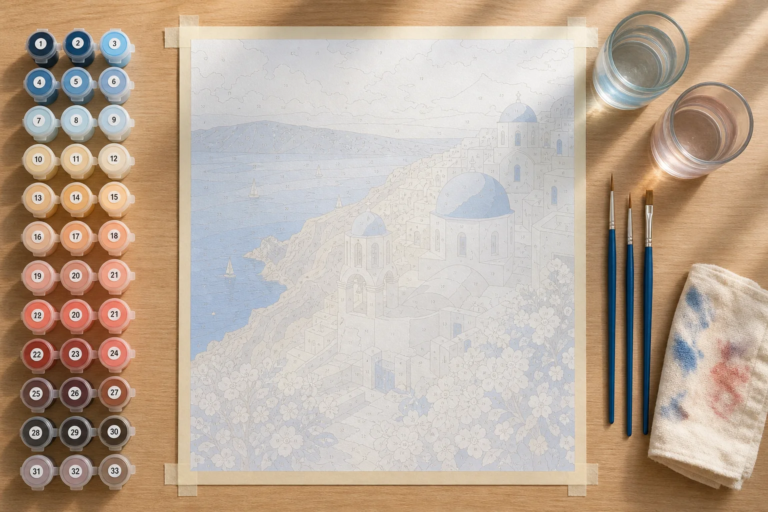 Geordende werkplek met vlak canvas verfpotjes penselen en twee waterglazen