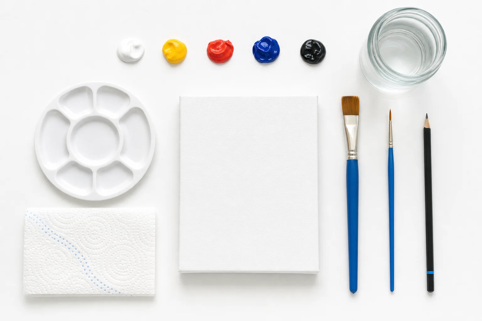 Minimale schilderset met vijf kleuren twee penselen palet water potlood en een klein wit doek