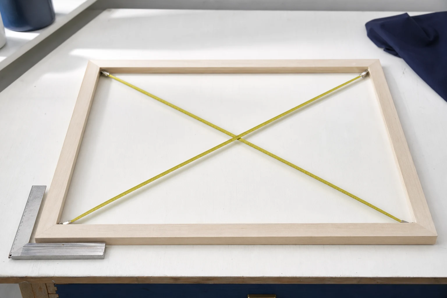 Houten frame waarvan beide diagonalen met meetlinten worden gecontroleerd