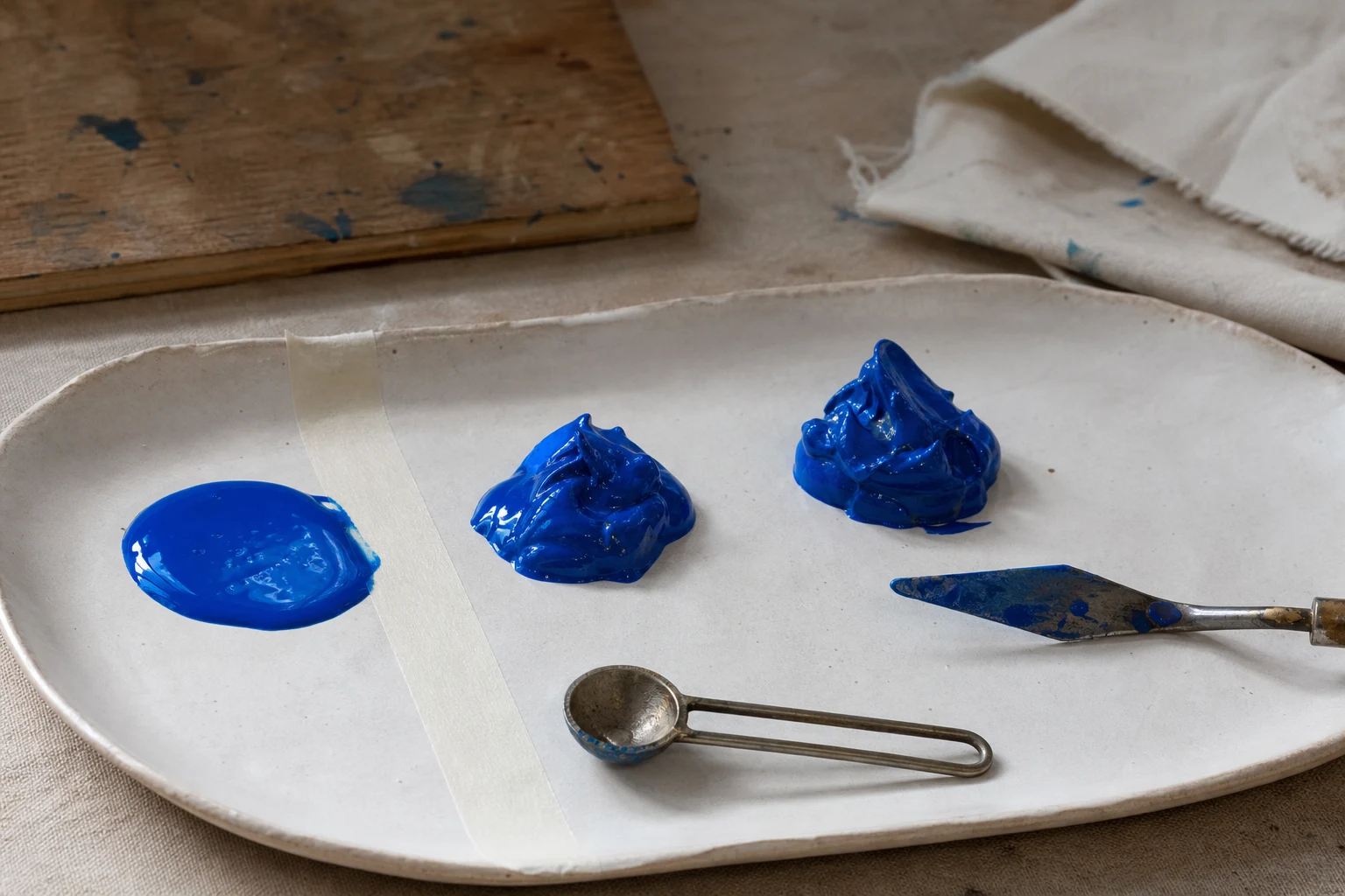 Kleine proefmengsels acrylverf en gel op een keramisch palet met maatlepeltje