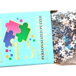 Geopende puzzeldoos met de zak puzzelstukjes erin